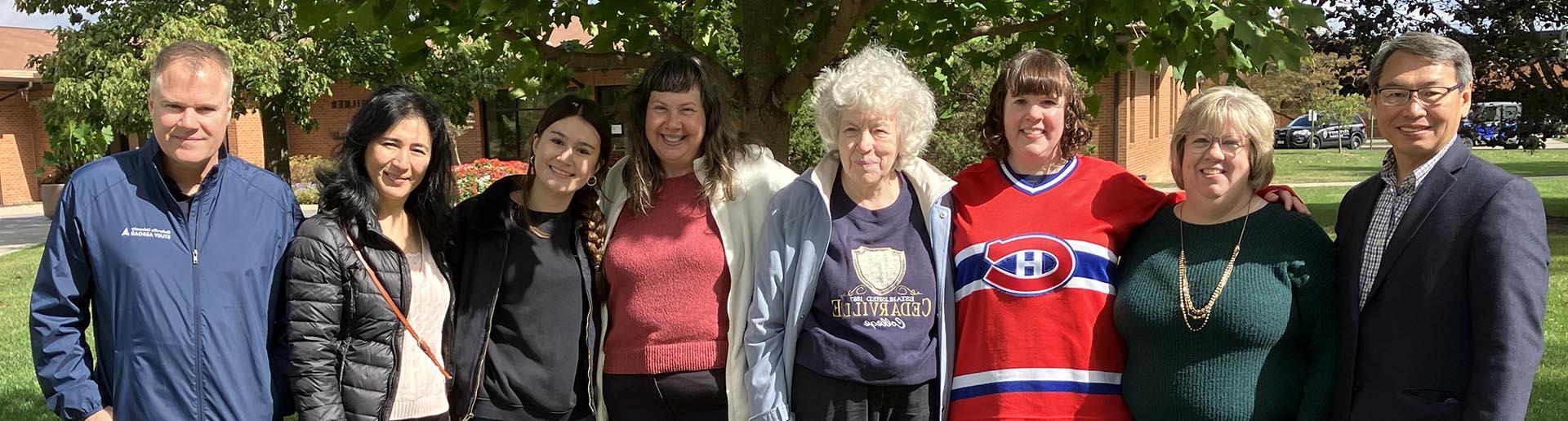 Julie Deardorff, Cedarville University colleagues and friends stand in front of the Dr. 校园里的Don Deardorff纪念树.